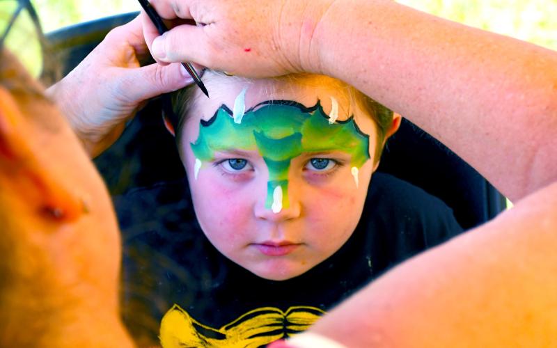 Dempsey Heupel, four, looks to embody the fierce dragon being painted on his face Aug. 9 during the Day County Fair. Kari Nelson, Webster, was the masterful artist behind many colorful children’s faces running around the Day County Fairgrounds. Heupel of Webster is the son of Jacob and Jessica Heupel. Reporter &amp;amp; Farmer | Amanda Dulitz
