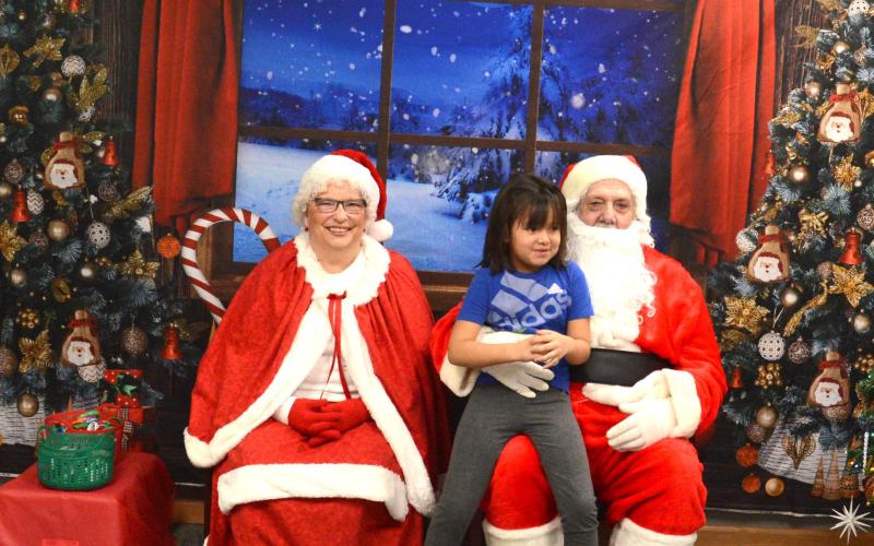That heartwarming smile a child gets when they see Mr. and Mrs. Claus makes the chaos of the season stop for only a minute. Mr and Mrs. Claus made a stop into Waubay Santa Day. This event was full of family fun with carnival games and bingo, all with prizes the children could win. Pictured are Mr. and Mrs. Claus with Ismeala Strutz, who was pretty excited to see Santa and tell him what she wanted for Chirstmas. Reporter &amp;amp; Farmer | Jessica Washenberger