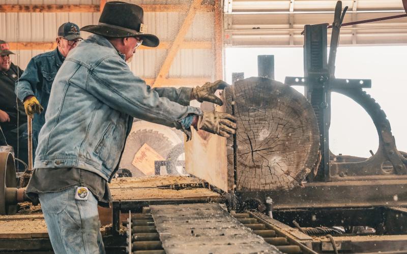 Clayton Larson guides a log through a saw blade in the Harold Brown Family Sawmill Sept. 6 at the James Valley Threshing Show in Andover. The sawmill has been operating during the show every year since 2013. Reporter &amp;amp; Farmer | Leyton Beardslee