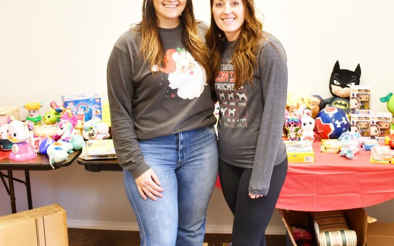 Chelsey Wood and Meagan Baumgarn hosted a free holiday clothing and toy drive at 708 Main St. Dec. 6-7. According to Wood, over eight boxes of donations were recieved from the community. Here from left, Wood and Baumgarn stand in front of a table with children’s toys donated for their drive Dec. 7. Reporter &amp;amp; Farmer | Brenner Cariveau