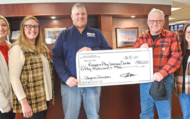 Members of the Knapp &amp;amp; Play Learning Center committee, from left, Lexi Rithmiller and Jenna Wik received a check presented by Joel and Roger Shoemaker Feb. 11. Also pictured is Rainy Hanson with the Webster Area Development Corporation. The Shoemakers made a $50,000 donation towards the Webster childcare center on behalf of their business, Webster Scale. Reporter &amp;amp; Farmer | Amanda Dulitz