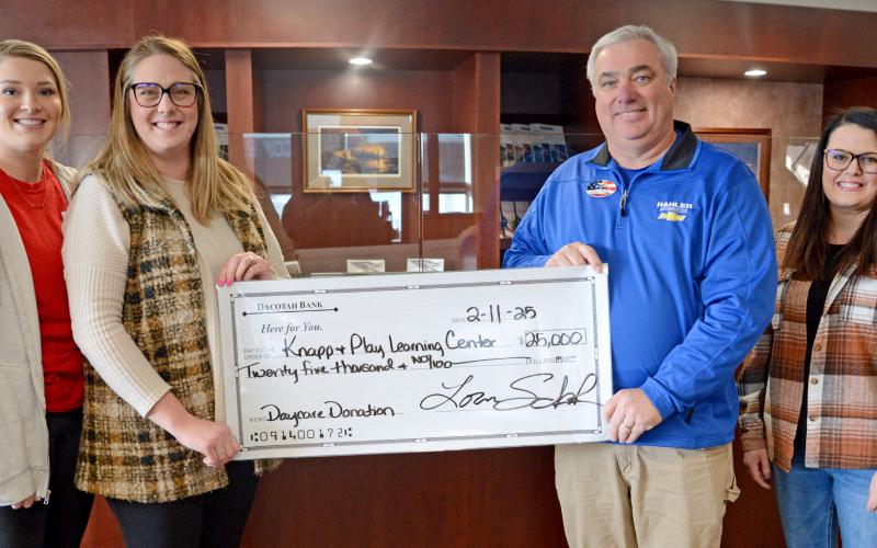 Lexi Rithmiller, Jenna Wik receive a check for $25,000 on behalf of the Knapp &amp;amp; Play Learning Center committee. The check was presented by Loren Shoenbeck, who gave the donation on behalf of himself and wife Lisa, from Dave Hahler Automotive. Also pictured is Rainy Hanson with the Webster Area Development Corporation. The presentation was made Feb. 11. Reporter &amp;amp; Farmer | Amanda Dulitz