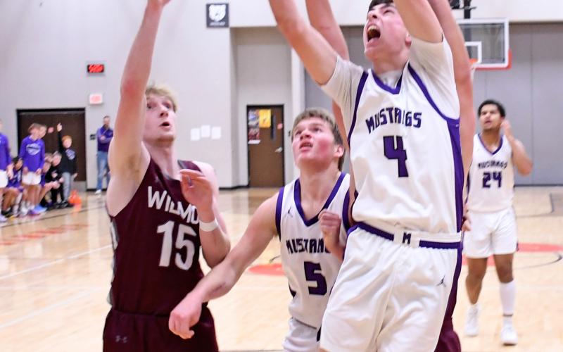 Waubay/Summit Mustang Tigh Gaikowski (4) pushes his way past a couple of Wilmot Wolves Jan. 11 to attempt a basket while Mustang Dylan Rumpza (5) looks on. The Mustangs hosted the Wolves in Summit running away with the victory 61-28. Reporter &amp;amp; Farmer | Robert Dulitz