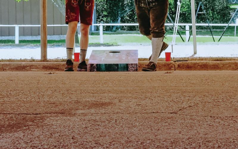 Corn hole players, from left, Tayne Dunse and Austin Norton both from Webster compete against each other in a corn hole tournament during Germanfest at Webster Armory Sept. 27. The annual event was held for its 22nd year. Reporter &amp;amp; Farmer | Leyton Beardslee