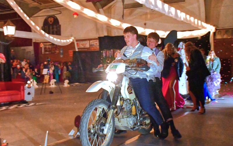 (Above) From left, Jack Snell and TJ Sonstebo start off the comedy side of the Grand March by driving through the armory on a motor-bike. Webster Area’s Grand March was turning into a confetti-water- bubble mess with students laughing as they entertained the crowd. Reporter &amp;amp; Farmer | Connor Handrahan