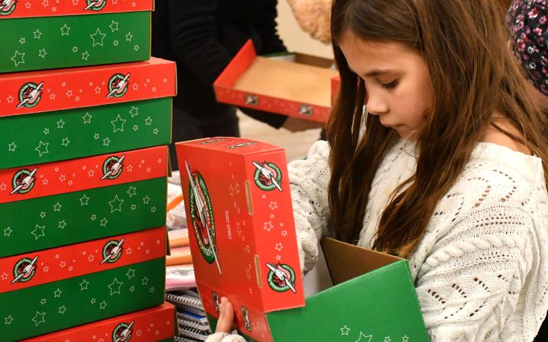 Hattie Miller with Girl Scout Troup 50657 helps pack boxes for Operation Christmas Child at Westside Wesleyan Church in Bristol Nov. 13. Miller is the daughter of Brandon Miller and Sarah Miller of Webster. Reporter &amp;amp; Farmer | Leyton Beardslee