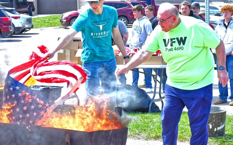 Webster Area School and Webster Veterans of Foreign Wars held a flag retirement ceremony May 8. Commander Kevin Bohn welcomed students and public members who were in attendance. From left, Gage Wik and Tom Lewno help burn flags as a way to show respect. Reporter &amp;amp; Farmer | Connor Handrahan