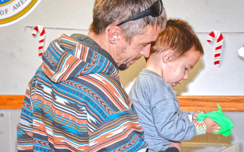 Waubay Senior Center had an inflatable pond for kids to pick out a rubber-duck for a prize at their Christmas celebration Dec. 6. Scott Harrington helped his son Noah Harrington pick out a toy to take home after picking a duck from the pond. Reporter &amp;amp; Farmer | Connor Handrahan