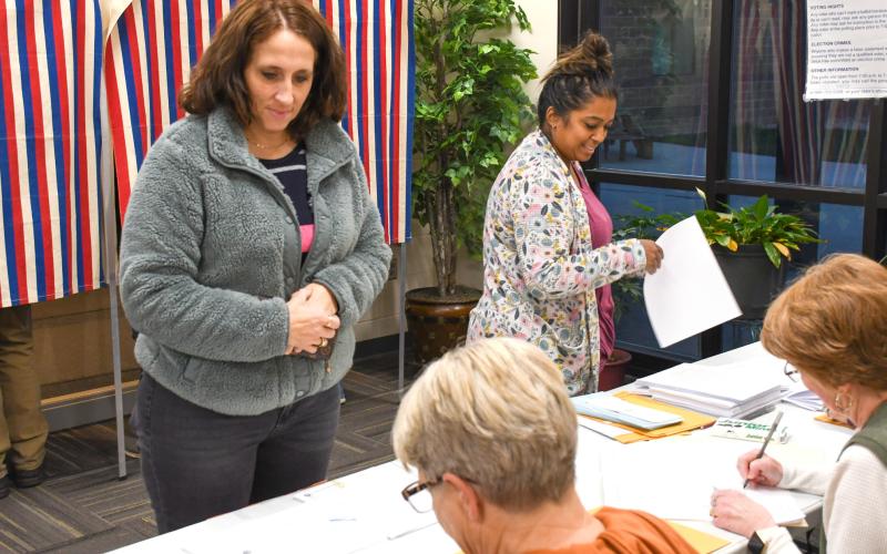 Jami Hubsch, left, and Kaylan Pool, right, each wait in line to cast their ballots Nov. 4 during Webster Area School District’s bond vote. Election officials Sandy Anderson, bottom left, and Bette Zenk, bottom right, helped record each voter who came to the polls that day. The 1,103 voters who cast their ballots represented a 42 percent voter turn out. The $12.5 million bond was ultimately voted down, 682-421. Reporter &amp;amp; Farmer | Amanda Dulitz