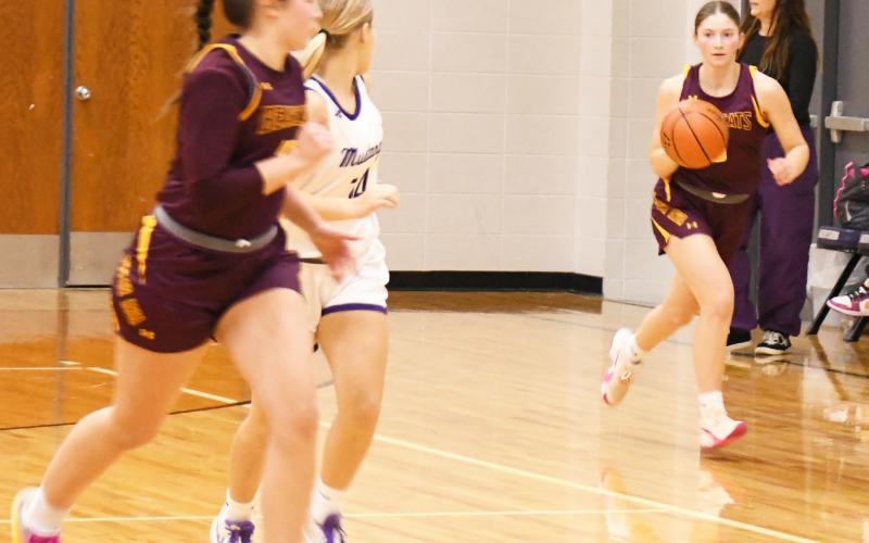 Webster Area Bearcats opened up their 2024-25 season with an overtime loss to the Waubay-Summit Mustangs in an away game 45-50 Dec. 10. Here, Webster Area guard Chloe Mammenga (5) brings the ball up court while her teammate Harley Johnson (10) runs up the court with Mustang defender Kaycee Berger (14) running the floor step for step with her. Reporter &amp;amp; Farmer | Robert Dulitz