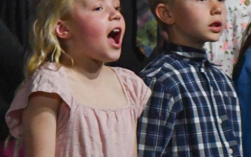 Webster Area Elementary students presented a unique twist to their spring concert April 18 when all students stood up and began singing at the conclusion of the event. Shown here are Adalynn Letcher and Kohenn Konradi, singing “As Long as the World Goes Around” with the entire school’s elementary choir. Reporter &amp;amp; Farmer | Amanda Dulitz