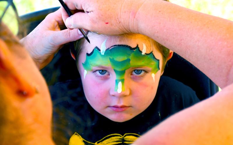 Dempsey Heupel, four, looks to embody the fierce dragon being painted on his face Aug. 9 during the Day County Fair. Kari Nelson, Webster, was the masterful artist behind many colorful children’s faces running around the Day County Fairgrounds. Heupel of Webster is the son of Jacob and Jessica Heupel. Reporter &amp;amp; Farmer | Amanda Dulitz