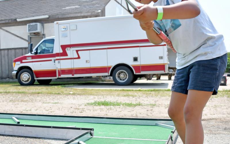 Five-year-old Lizbeth Mercado takes a swing at a golf ball, sending it flying down the course at the mini golf station during Waubay Fun Fest July 20. The youth is from Watertown and was enjoying the day with her mom Jessica Mercado. Reporter &amp;amp; Farmer | Amanda Dulitz