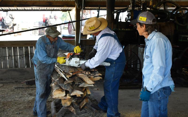 James Valley Threshing Show Sept. 6-8 hosted various antique agricultural equipment and other activities including an engine room, craft booths and a saw mill area in Andover. Starting on the left, Harris Billigmeier, Jeff Edin and Jane Larson are cutting lumber which would need to dry out. The processed lumber would then be used as the fuel source for the engine of the Case machine pictured behind the trio. Reporter &amp;amp; Farmer | Brenner Cariveau