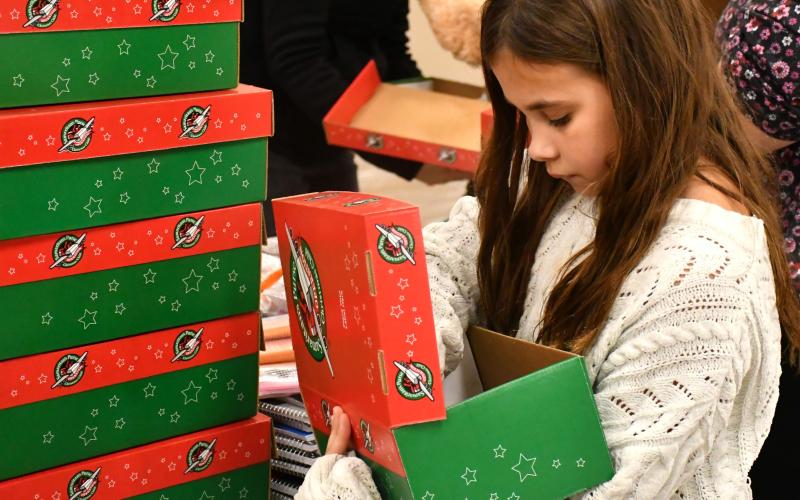 Hattie Miller with Girl Scout Troop 50657 helps pack boxes for Operation Christmas Child at Westside Wesleyan Church in Bristol Nov. 13. Miller is the daughter of Brandon Miller and Sarah Miller of Webster. Reporter &amp; Farmer | Leyton Beardslee