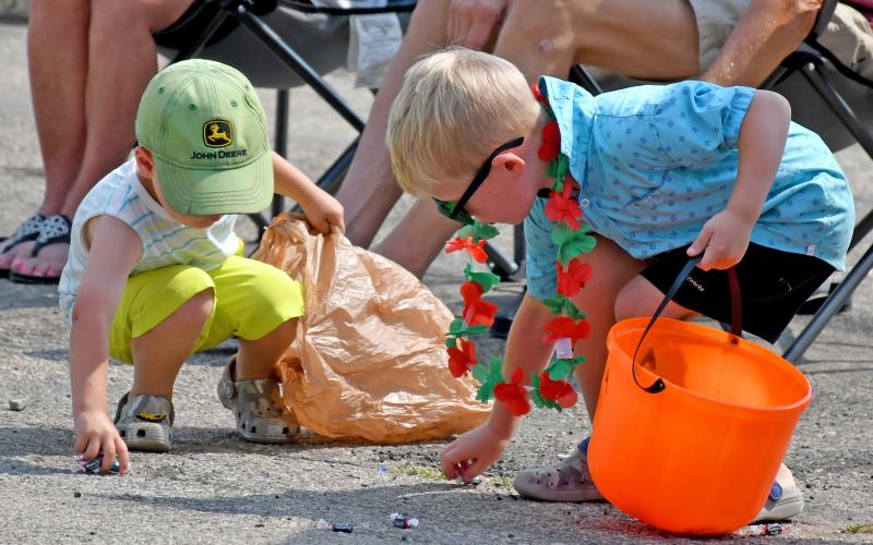 Kash Hoven, two, and Hayes Spiering, five, scramble to collect as much candy as they can during the Waubay Fun Fest parade July 20. Hoven is the son of Josh and Lauren Hoven of Webster, while Spiering is the son of Chris and Sarah Spiering, Webster. Reporter &amp;amp; Farmer | Amanda Dulitz