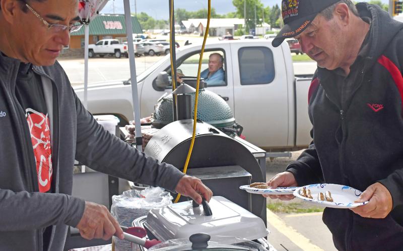 A block party was held June 27 at Webster Ace where the store celebrated the 100th anniversary of Ace Hardeware. Free food was served and activites were held throughout the day. Pictured here, Webster Ace co-owner Alfredo Garduno serves breakfast sausages to Webster community member Dave Fromelt. Reporter &amp;amp; Farmer | Luke Caputo
