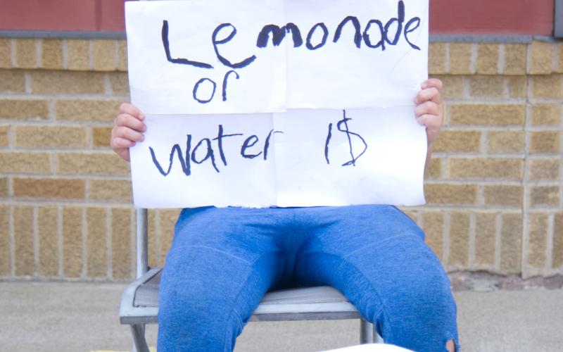 Dylan Ellis, age 11, son of Mike and Tami Ellis of Webster sells lemonade and water on the south end of Main St. in Webster Aug. 19. Ellis said he is saving up for a four-wheeler and had raised over $100 so far. Reporter &amp;amp; Farmer | Leyton Beardslee