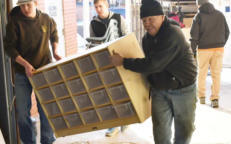 In order to renovate the Knapp &amp;amp; Play Learning Center building for a Webster day care, old furniture was being transported to the Lake Region Business Center Feb. 21 for storage. Here from left, Caleb Gaikowski, Gabriel Gaikowski and Nathan Meland haul a large organizer into a storage area. Reporter &amp;amp; Farmer | Brenner Cariveau