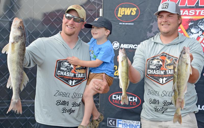 Showing off their fish from day two of the Masters Walleye Tournament are Waubay residents Joe Unzen with his three-year-old son Henry and his tournament partner Justin Zirbel. Reporter &amp;amp; Farmer | Amanda Dulitz