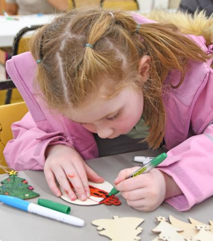 Reporter &amp; Farmer Amanda Dulitz At right Four-year-old Iyla Warner colors a wooden Christmas tree ornament Dec. 1 at the Day County Arts Center in Webster during a community event held there. Warner is the daughter of Mia Hannan and Cody Warner.
