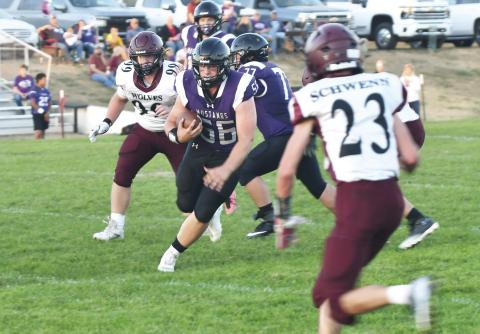 Senior running back Brooks Dolen (56) rushes the ball for the Waubay-Summit Mustangs as they faced off against the Wilmot Wolves Sept. 27. The Mustangs were able to secure their second win of the season with a score of 52-12 over Wilmot. Pictured behind Dolen is offensive lineman Will Althoff (77). Reporter &amp; Farmer | Brenner Cariveau