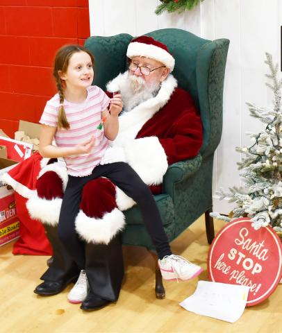 Roslyn booster club appreciation day took place Dec. 6 at the Roslyn Center in which a free meal was provided, inflatables for kids were present and Santa made an appearance. Here, eight-year-old Libby Huggett from Roslyn tells Santa her Christmas wishes which include an electric scooter. Taking Huggett to the event to meet Santa was her grandparents Melanie and Kim Remily. Reporter &amp; Farmer | Brenner Cariveau