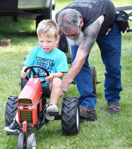 The pedal pull was a major attraction for many Day County youth during the Day County Fair. Three-yearold Hux, son of Justin and Tarah McClurg, participated in the pedal pull Aug. 10. The young Webster native applies force to the heavy tractor as Russell Larson provides a gentle push. During the Day County Fair children wanted to prove their worth in the pedal pull event and earn a trophy for their hard work. Reporter &amp; Farmer | Brenner Cariveau