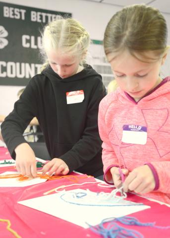 Cousins Hilton and Mallory Butler work on their yarn art at the Day County South Dakota Farmers Union Day Camp. The camp took place May 27 at the Day County Fairgrounds. Attendees learned about cooperatives along with renewable energy. Reporter &amp; Farmer | Annie Witt