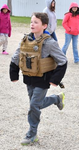 Waubay student Harlan Olson participates in the safety training held at Day County Fairgrounds May 6. Olson put on a South Dakota Highway Patrol officer’s vest and tries to run in it. Reporter &amp; Farmer | Connor Handrahan