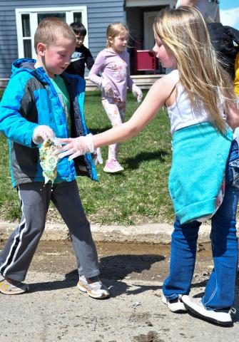 Levi Linde and Harlow Heupel, members of Webster Area Elementary kindergarden class, walked with classmates through the streets of Webster April 22 to clean up any garbage they found. Here, the pair work to clean up a sopping sandwich wrap which had gotten wet in the street. Reporter &amp; Farmer | Amanda Dulitz