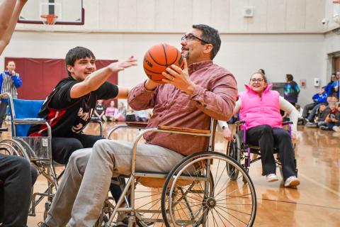 Webster Area third grade teacher Jared Vergeldt looks to shoot while being defended by student Jack Shoemaker during the annual wheelchair basketball game between Webster Area staff and FFA club members Feb. 25 at Webster Area High School. Students would go on to win the game 20-14. Reporter &amp; Farmer | Leyton Beardslee