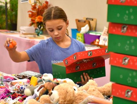 Naomi Acree, age eight, with Girl Scout Troop 50657 helps pack boxes for Operation Christmas Child at Westside Wesleyan Church in Bristol Nov. 13. Acree is the daughter of Mike and Jenny Acree, Webster. Reporter &amp; Farmer | Leyton Beardslee