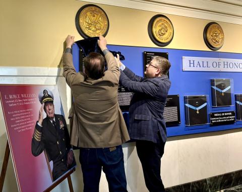 South Dakota Gov. Larry Rhoden, left, and Lt. Gov. Tony Venhuizen unveil a plaque for retired U.S. Navy Capt. E. Royce Williams in the Hall of Honor at the Capitol in Pierre on March 25. Reporter &amp; Farmer | South Dakota Searchlight, Meghan O’Brien