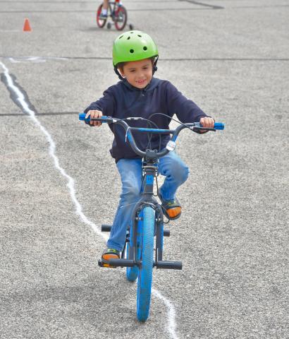 Chad Anderson focuses on keeping his bike on the line during a bike rodeo in the Webster Armory parking lot May 27. The bike safety event was held in conjunction with Webster Public Library’s summer reading program. Reporter &amp; Farmer | Leyton Beardslee