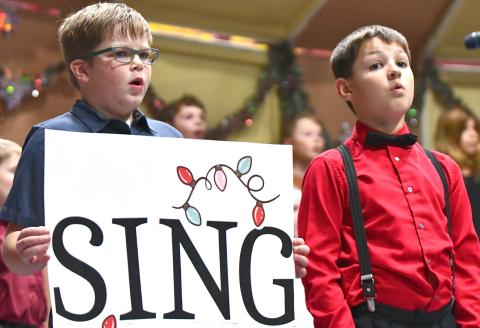 Webster Area third grade students, from left, Rhiley Zimmerman and Archer Chevalier sing during the school’s elementary winter concert Dec. 8 at the Webster Armory. Reporter &amp; Farmer | Leyton Beardslee