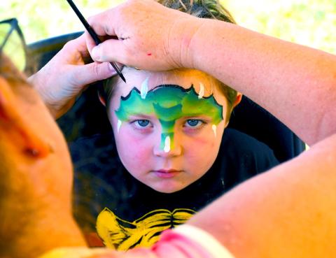 Dempsey Heupel, four, looks to embody the fierce dragon being painted on his face Aug. 9 during the Day County Fair. Kari Nelson, Webster, was the masterful artist behind many colorful children’s faces running around the Day County Fairgrounds. Heupel of Webster is the son of Jacob and Jessica Heupel. Reporter &amp; Farmer | Amanda Dulitz