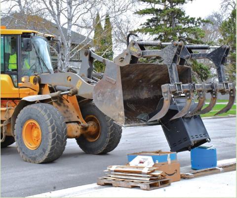 Webster’s annual city wide clean up started April 27. A city crew passed every street and picked up any trash left by residents. Here, John VanBeek operates a loader to pick up a pile of items left on the curb at W. 7th Ave. April 28. Reporter &amp; Farmer | Connor Handrahan