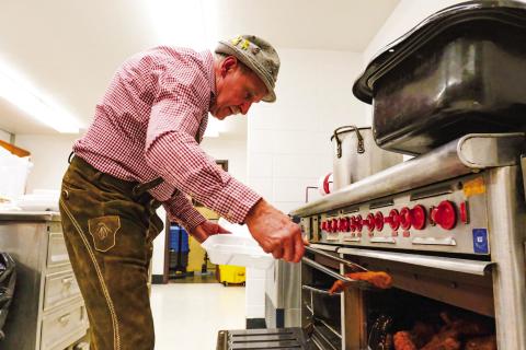 Webster Mayor Mike Grosek takes some schnitzel out of the oven for the traditional German meal served during Germanfest at Webster Armory Sept. 27 (see more on page 14). Reporter &amp; Farmer | Leyton Beardslee