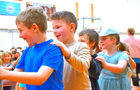 From left, Ronin Smidt, Theodore McDaniel, Bentley Breese and Vivian Garry particpate in the congo line during Phil Baker’s concert at Webster Area Elementary School May 14. Baker performed a variety of songs for the elementary students. Reporter &amp; Farmer | Connor Handrahan