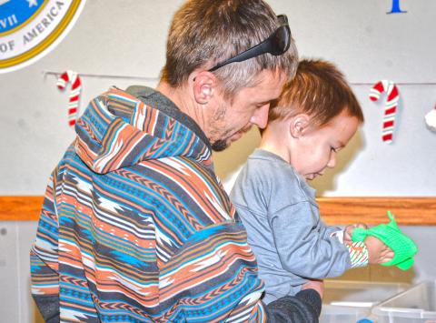 Waubay Senior Center had an inflatable pond for kids to pick out a rubber-duck for a prize at their Christmas celebration Dec. 6. Scott Harrington helped his son Noah Harrington pick out a toy to take home after picking a duck from the pond. Reporter &amp; Farmer | Connor Handrahan
