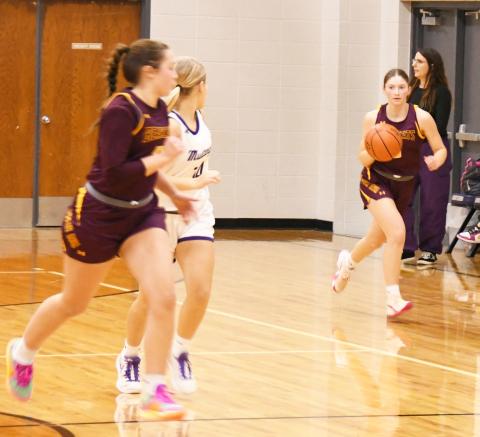 Webster Area Bearcats opened up their 2024-25 season with an overtime loss to the Waubay-Summit Mustangs in an away game 45-50 Dec. 10. Here, Webster Area guard Chloe Mammenga (5) brings the ball up court while her teammate Harley Johnson (10) runs up the court with Mustang defender Kaycee Berger (14) running the floor step for step with her. Reporter &amp; Farmer | Robert Dulitz