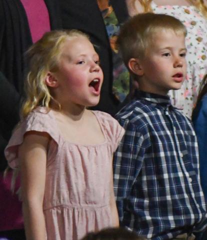 Webster Area Elementary students presented a unique twist to their spring concert April 18 when all students stood up and began singing at the conclusion of the event. Shown here are Adalynn Letcher and Kohenn Konradi, singing “As Long as the World Goes Around” with the entire school’s elementary choir. Reporter &amp; Farmer | Amanda Dulitz