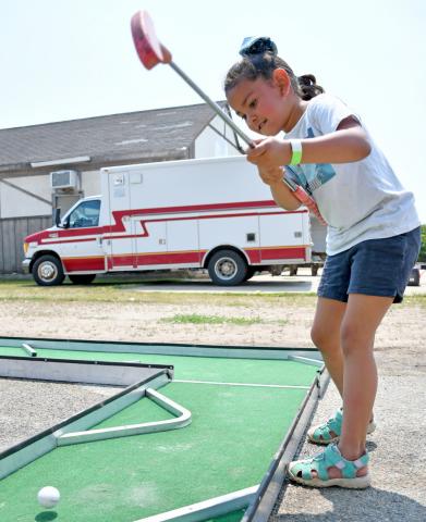 Five-year-old Lizbeth Mercado takes a swing at a golf ball, sending it flying down the course at the mini golf station during Waubay Fun Fest July 20. The youth is from Watertown and was enjoying the day with her mom Jessica Mercado. Reporter &amp; Farmer | Amanda Dulitz