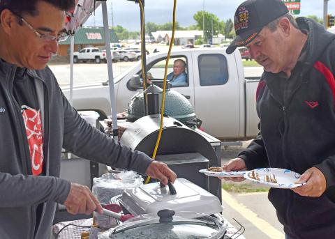 A block party was held June 27 at Webster Ace where the store celebrated the 100th anniversary of Ace Hardeware. Free food was served and activites were held throughout the day. Pictured here, Webster Ace co-owner Alfredo Garduno serves breakfast sausages to Webster community member Dave Fromelt. Reporter &amp; Farmer | Luke Caputo