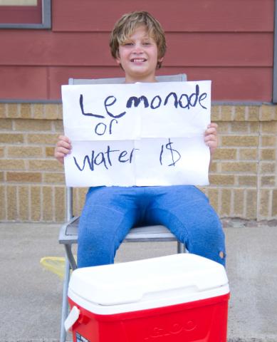 Dylan Ellis, age 11, son of Mike and Tami Ellis of Webster sells lemonade and water on the south end of Main St. in Webster Aug. 19. Ellis said he is saving up for a four-wheeler and had raised over $100 so far. Reporter &amp; Farmer | Leyton Beardslee
