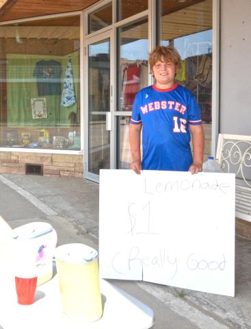 Lemonade stand proprietor Dylan Ellis, soon to be 13 years old, set up his storefront on Main Street, Webster July 27. Ellis said business is booming thanks to the warm weather and daytime traffic. He is saving his profits to fund the purchase of a four-wheeler and said he is getting “kinda” close to his goal. Reporter &amp; Farmer | Timothy Gibson