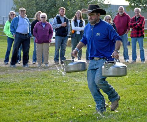 Sam Hubsch races with a pair of milk pails in the Fittest Farmer contest at the first annual Harvest Bash Sept. 6 where contestants were pitted against not only each other but also against various obstacles. Reporter &amp; Farmer | Amanda Dulitz