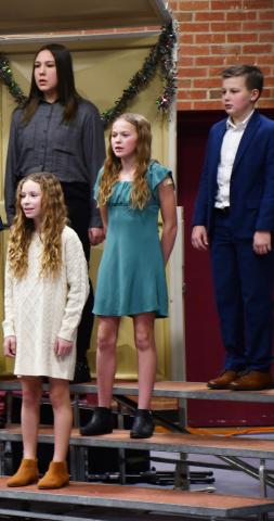 Webster Area students k-6 performed at the winter concert event Dec. 9 at the Webster Armory. Here, sixth graders left in back Kailani Andrade and Harrison Wagner; in middle row Portlyn Johnson and in front Embry Duenwald sing holiday songs. Reporter &amp; Farmer | Brenner Cariveau