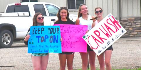 From left, Ava Bjerke, Kenslee Zubke, Kinsey Kuecker and Cartney Hanson are waving down cars and advertising for their car wash. Webster Area Key Club hosted a topless car wash June 1 for four hours. Reporter &amp; Farmer | Connor Handrahan